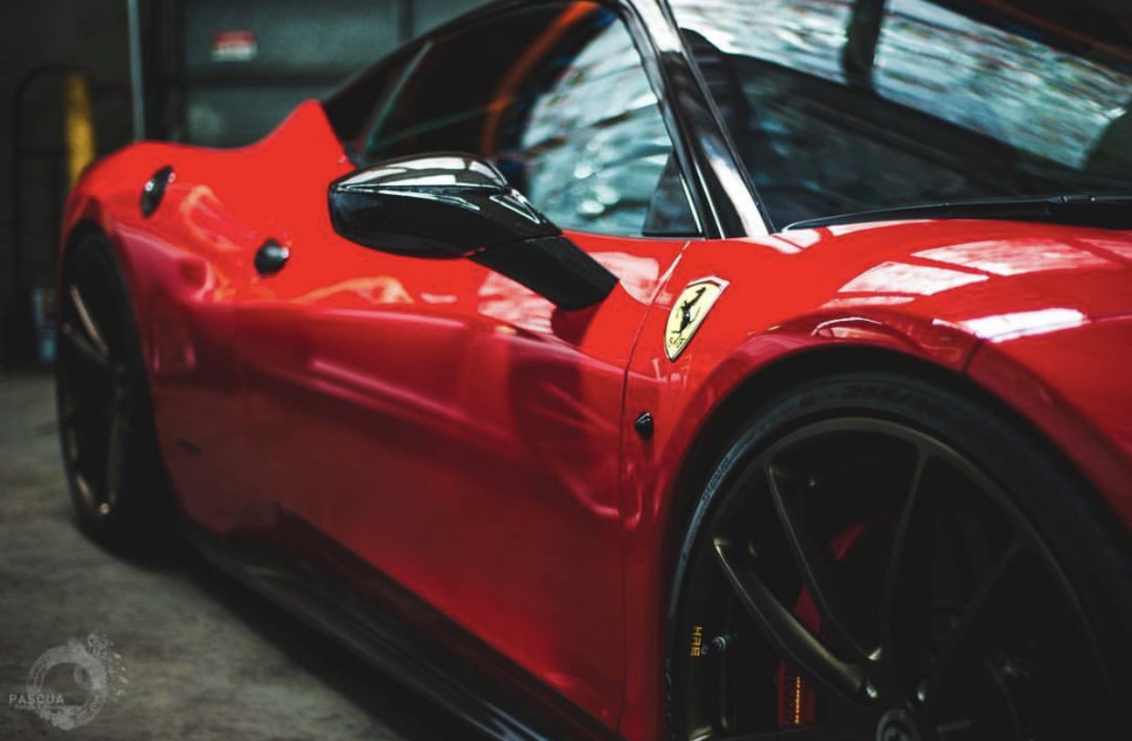 A red ferrari is parked in the garage.