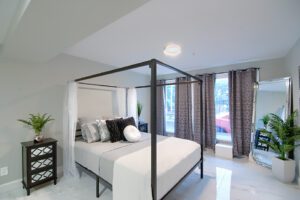 A bedroom with white walls and black furniture.