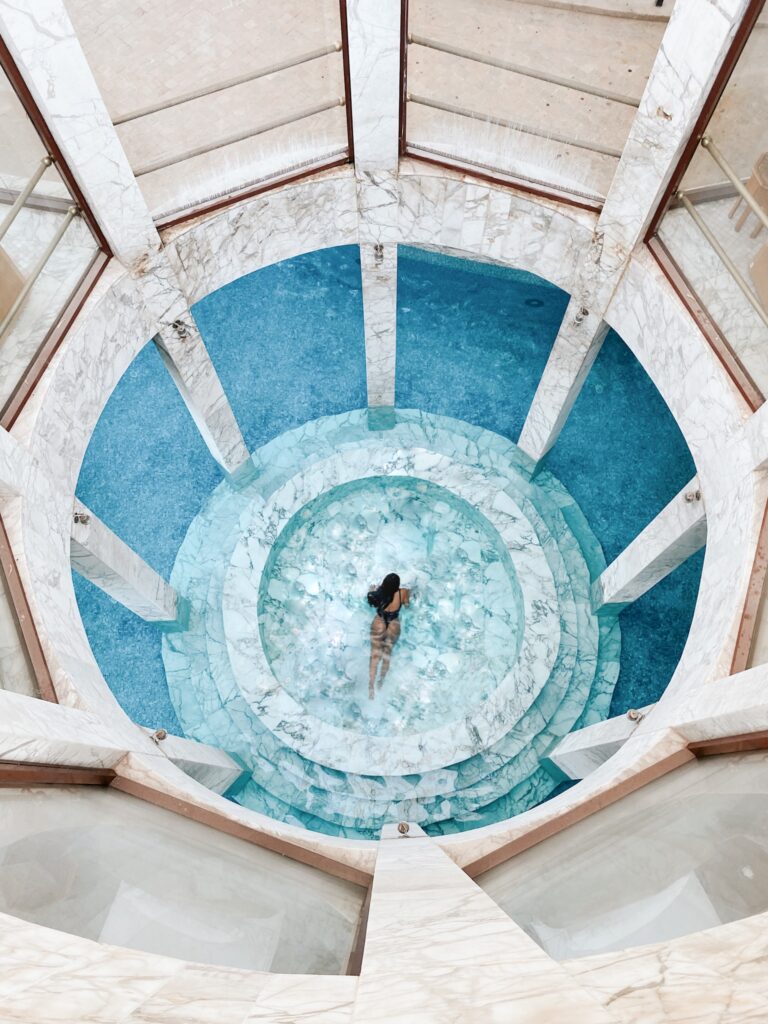 A person standing in the middle of an indoor pool.