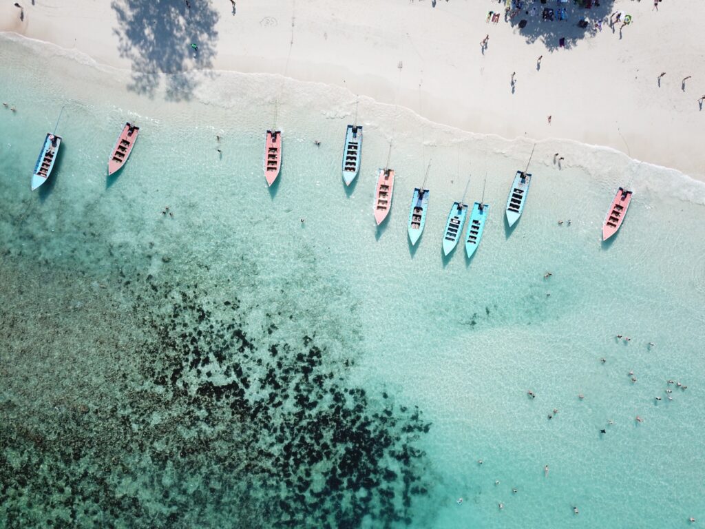 A group of boats are lined up on the beach.