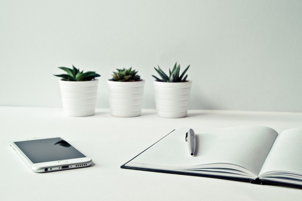 A table with three plants and a cell phone