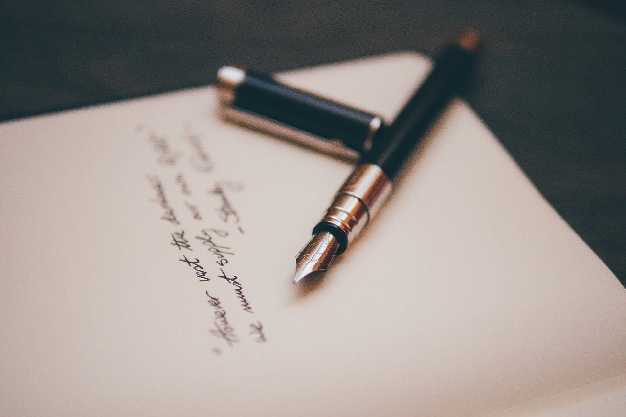 A pen and paper on top of a table.