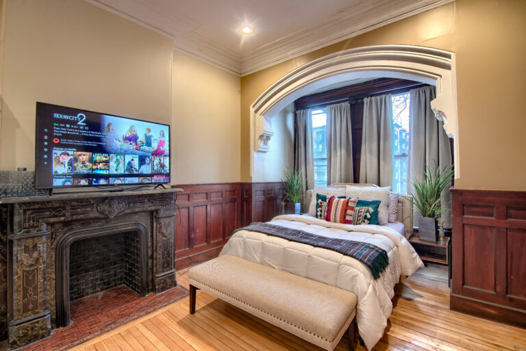 A bedroom with a fireplace and television in it