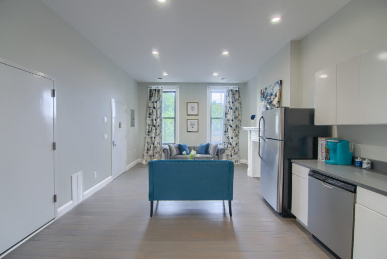 A living room with a couch and refrigerator