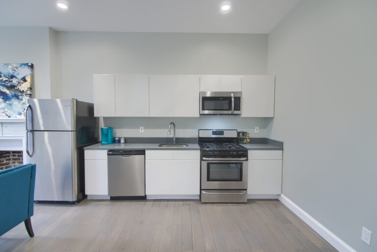 A kitchen with white cabinets and stainless steel appliances.