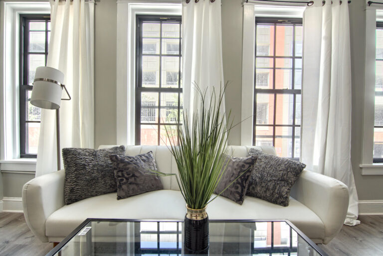 A living room with white walls and black furniture.