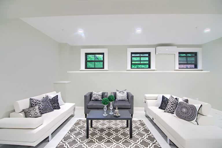 A living room with white furniture and black coffee table.