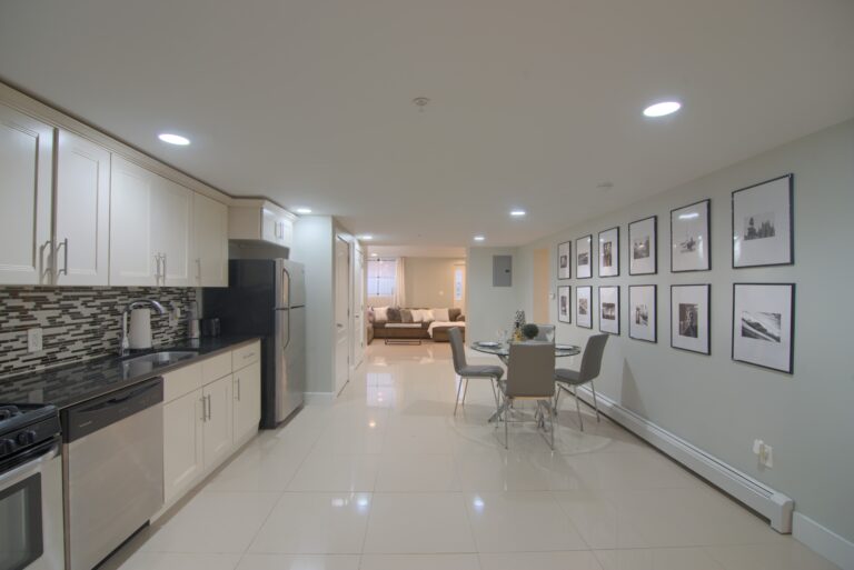 A kitchen with white cabinets and tiled floors.