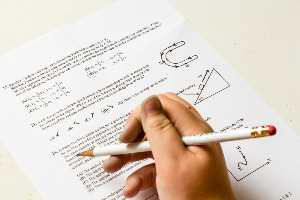 A person is writing on paper with some math equations