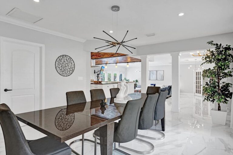 A dining room table with chairs and a mirror