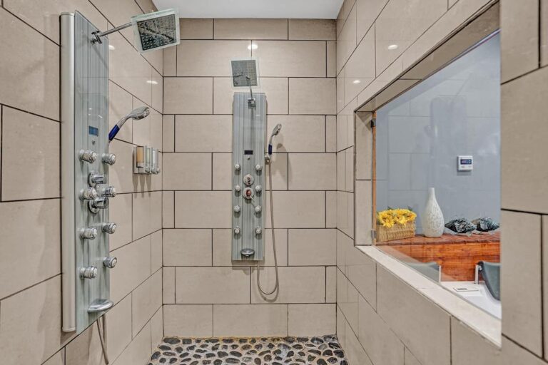 A bathroom with a shower and tiled walls.