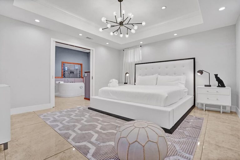 A bedroom with a large bed and white walls.
