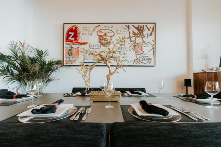 A dining room table with silverware and napkins on it.