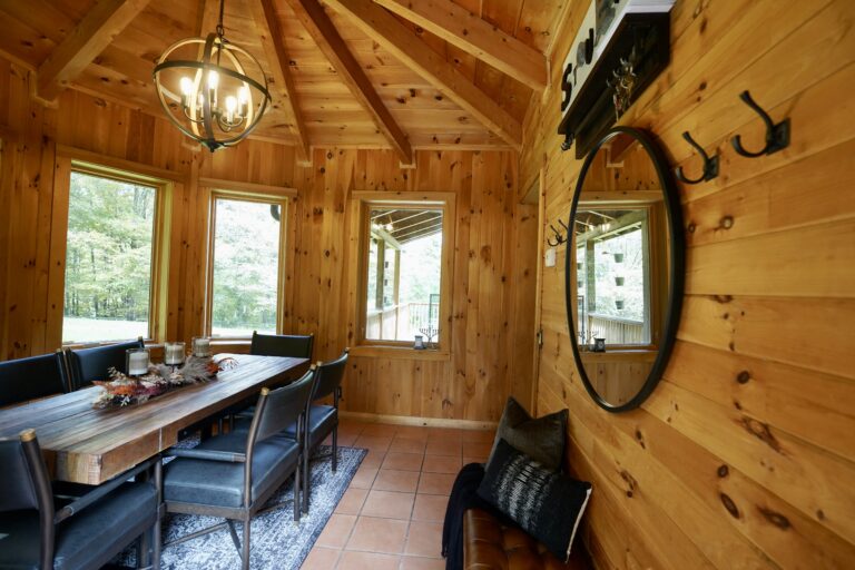 A dining room with wooden walls and ceiling.