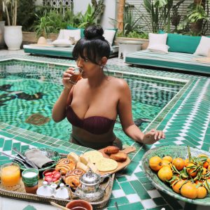 A woman sitting in the pool with food on her lap.